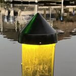 Mounted on top of dock wood pilings. 12V DC LED. Black vinyl cone cap shell. 2000 Lumen. Powered by plug-in transformer. Programmable timer with photo-eye. Optional dimmability by remote. 7W. Warm white – color temperature 2700 K. Incl. 2” stainless mounting screws and spacers.